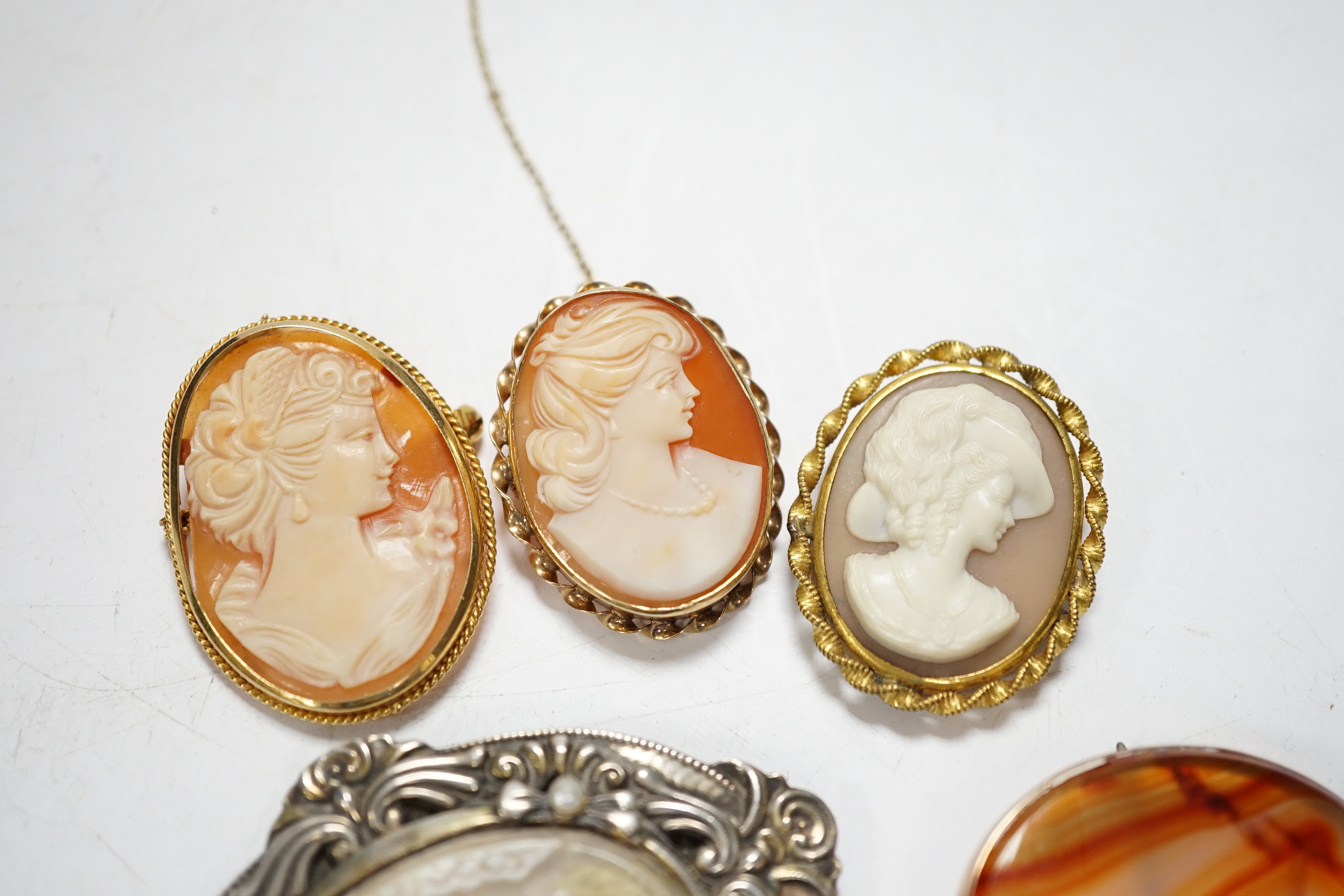 Two modern 9ct gold mounted oval cameo shell brooches, a 9ct gold and cameo shell set ring, three other cameo shell set brooches and a 9ct and banded agate set oval brooch, 40mm.